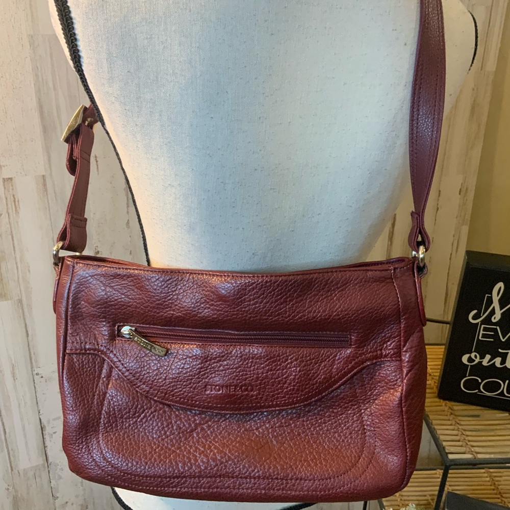 Stone & Co maroon bag with three zipper pockets.